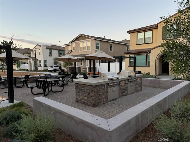 patio terrace at dusk with area for grilling and exterior kitchen