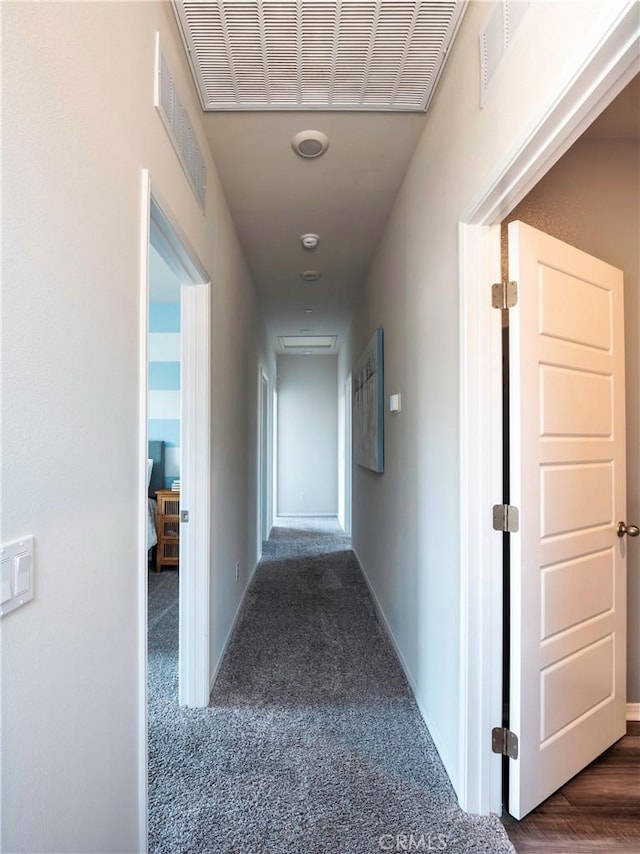 hallway featuring dark carpet