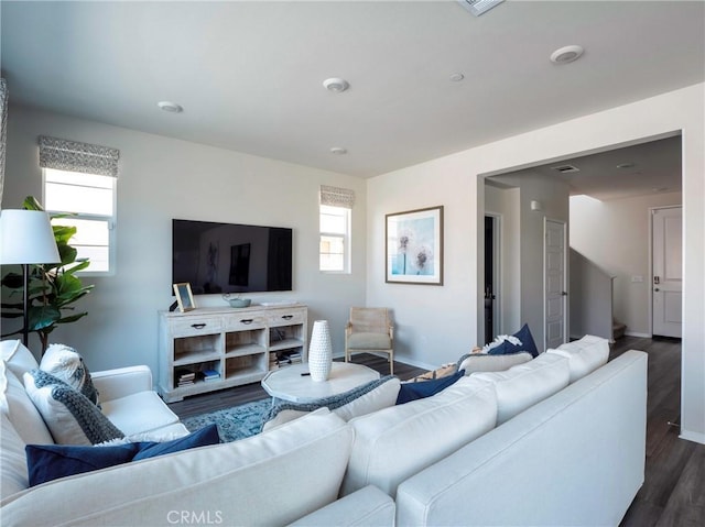 living room featuring dark wood-type flooring and plenty of natural light