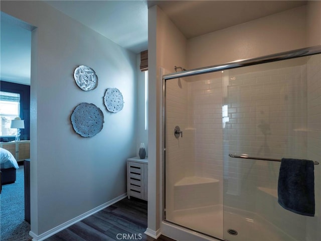 bathroom with a shower with door and hardwood / wood-style floors