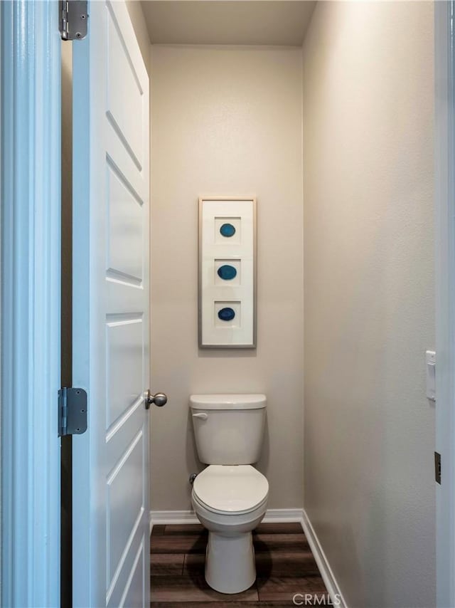 bathroom featuring hardwood / wood-style flooring and toilet