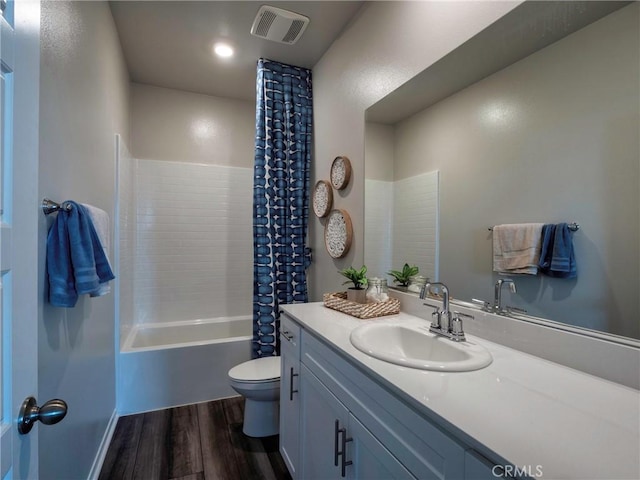 full bathroom with shower / bath combo, hardwood / wood-style floors, vanity, and toilet