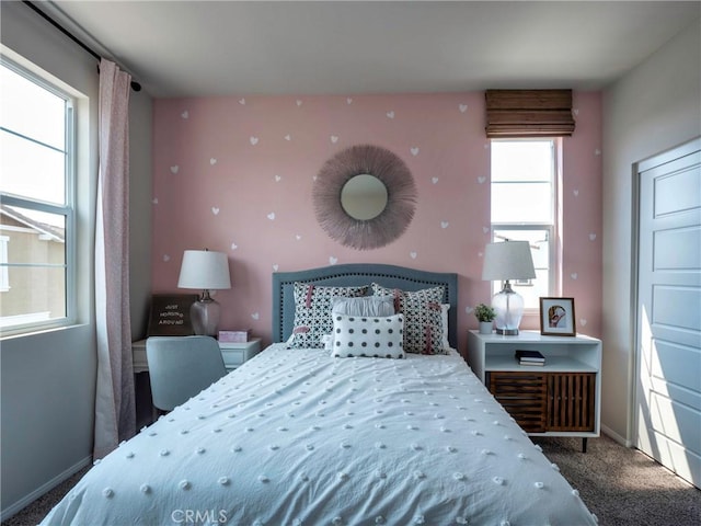 bedroom featuring multiple windows and dark colored carpet