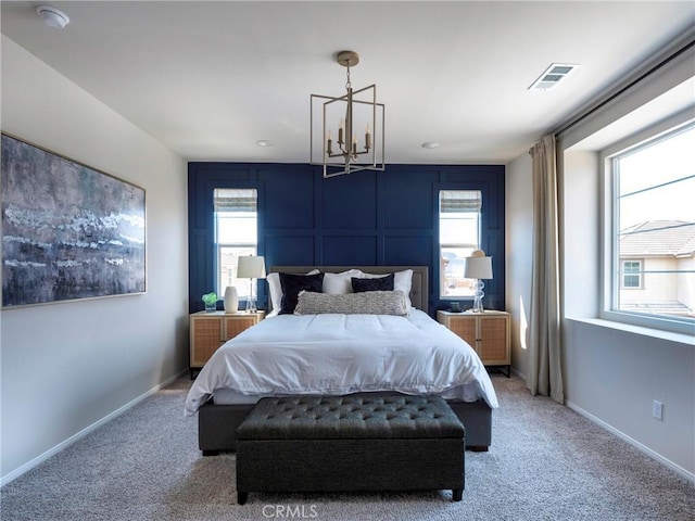 bedroom with multiple windows, a chandelier, and carpet