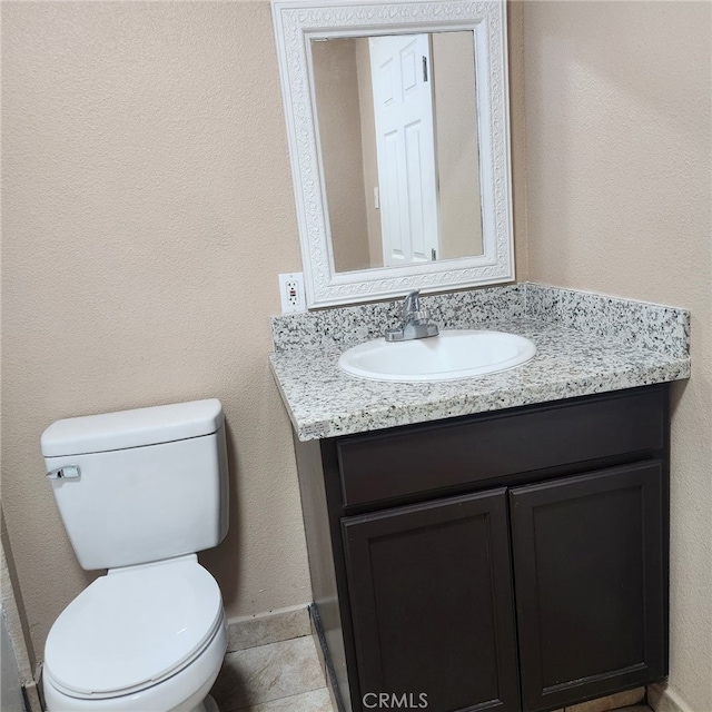 bathroom featuring vanity, tile patterned floors, and toilet