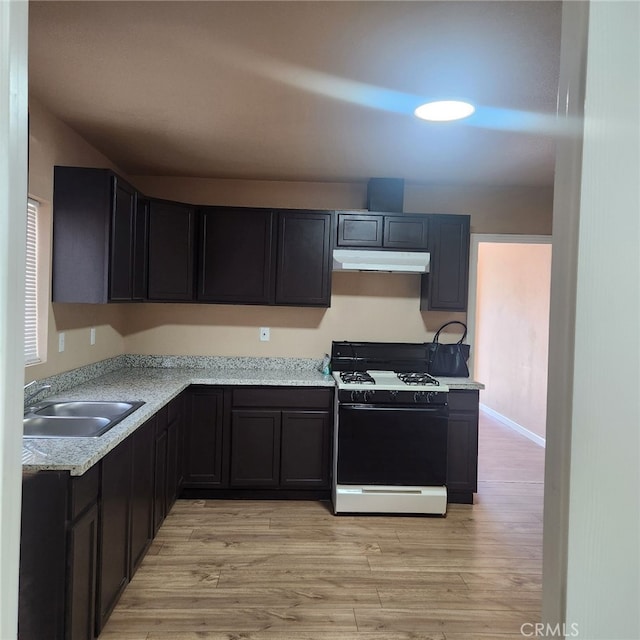 kitchen with light stone counters, sink, range with gas cooktop, and light hardwood / wood-style floors