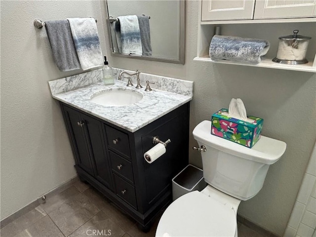 bathroom featuring vanity, baseboards, and toilet