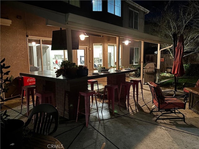 view of patio with fence, grilling area, and outdoor dry bar