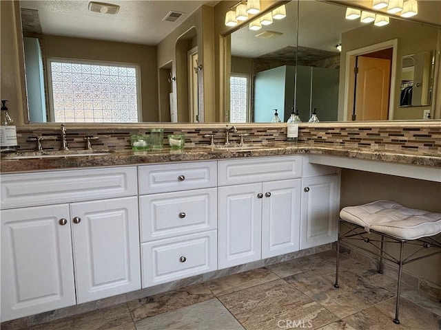 bathroom with visible vents, a sink, and tasteful backsplash