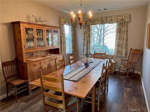 dining area featuring baseboards, a notable chandelier, dark wood-style floors, and visible vents