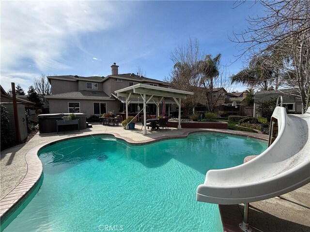 view of swimming pool featuring fence, a gazebo, a water slide, a fenced in pool, and a patio