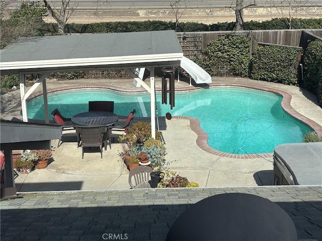 view of pool featuring a gazebo, a water slide, a fenced backyard, a fenced in pool, and a patio