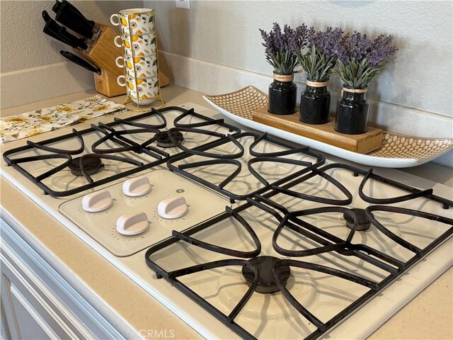 details featuring a textured wall and white stovetop