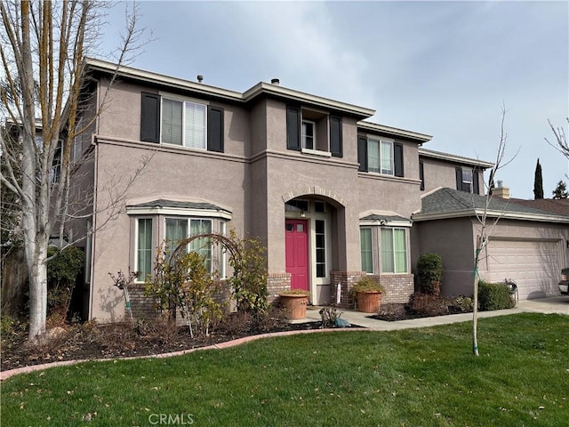 view of front facade featuring brick siding, a garage, stucco siding, and a front yard