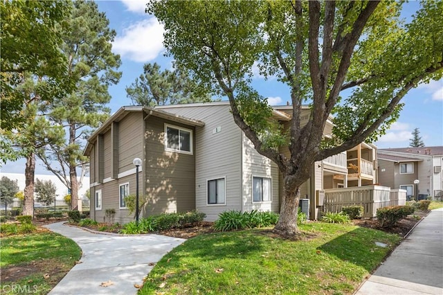 exterior space with a balcony and a front yard