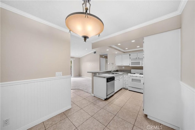 kitchen with light tile patterned flooring, ornamental molding, kitchen peninsula, white appliances, and white cabinets