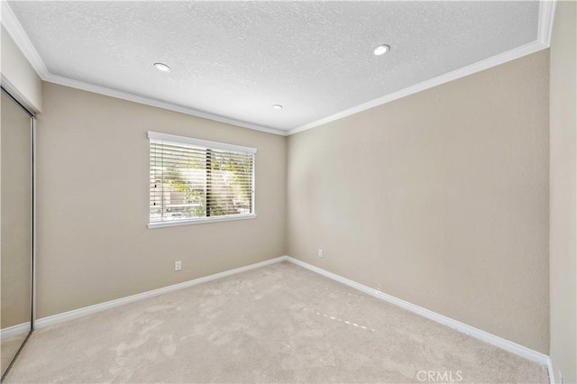 unfurnished bedroom featuring crown molding, light carpet, a textured ceiling, and a closet