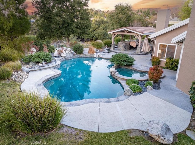 pool at dusk featuring an in ground hot tub, a patio area, and a gazebo