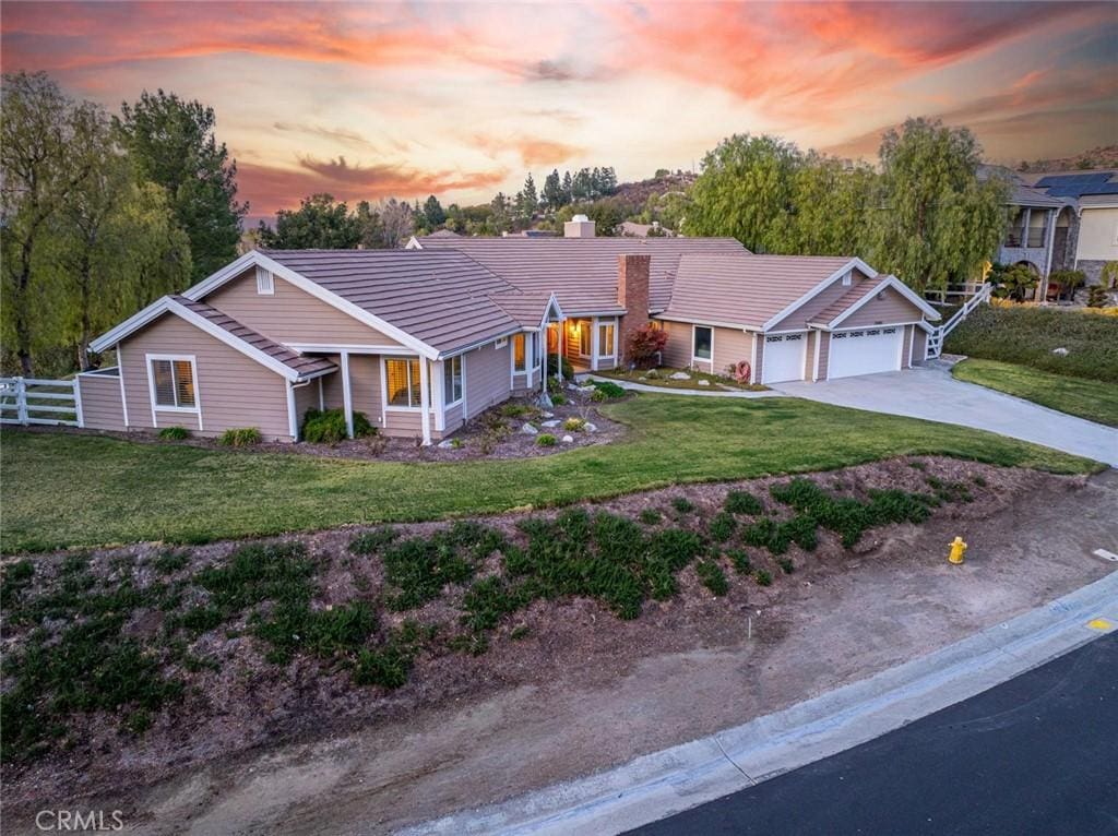 ranch-style home with a garage and a lawn