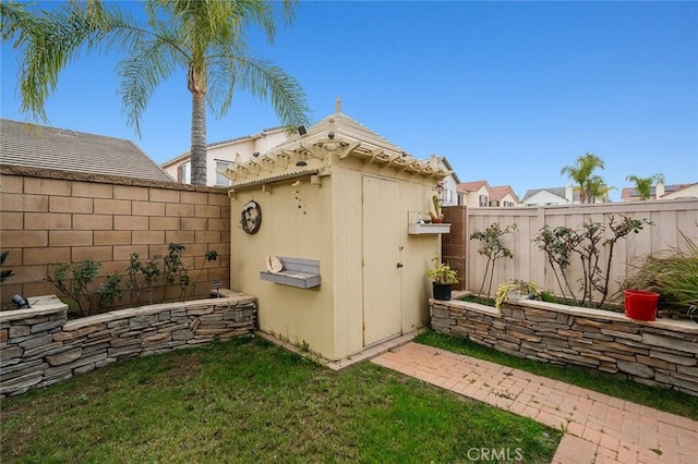 view of side of home featuring a lawn and a shed