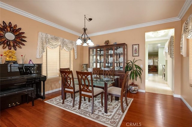 dining area featuring crown molding, dark hardwood / wood-style floors, and a chandelier