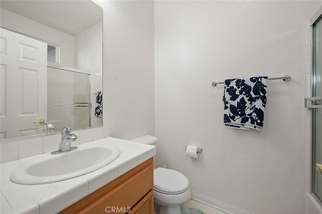 bathroom with vanity, a shower with shower door, and toilet