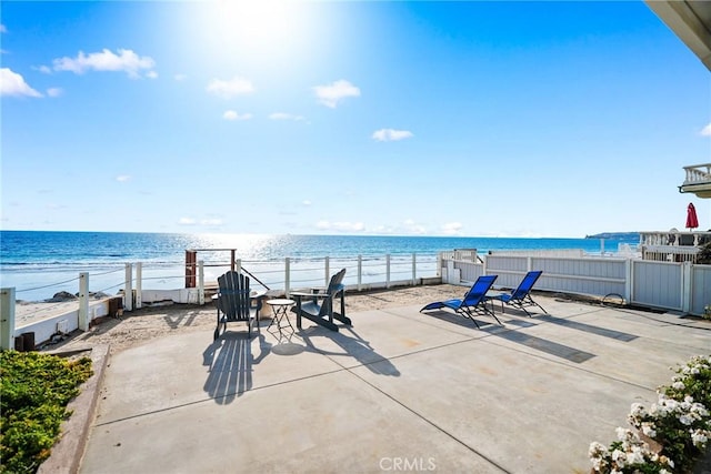 view of patio / terrace with a water view and a view of the beach