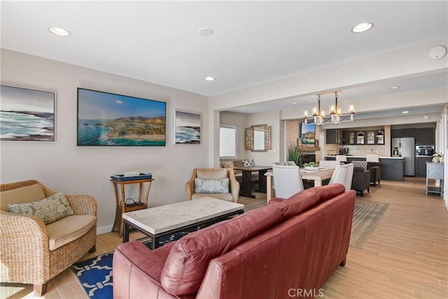 living room with an inviting chandelier and light hardwood / wood-style floors