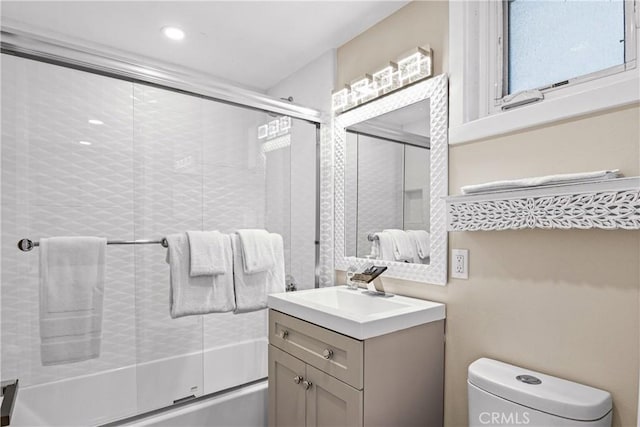 full bathroom featuring vanity, shower / bath combination with glass door, and toilet