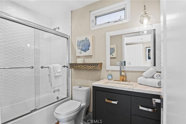 full bathroom featuring bath / shower combo with glass door, vanity, and toilet