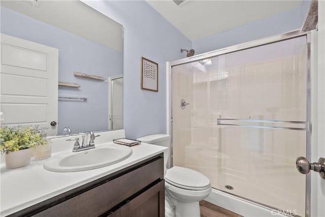 bathroom with walk in shower, vanity, toilet, and hardwood / wood-style floors