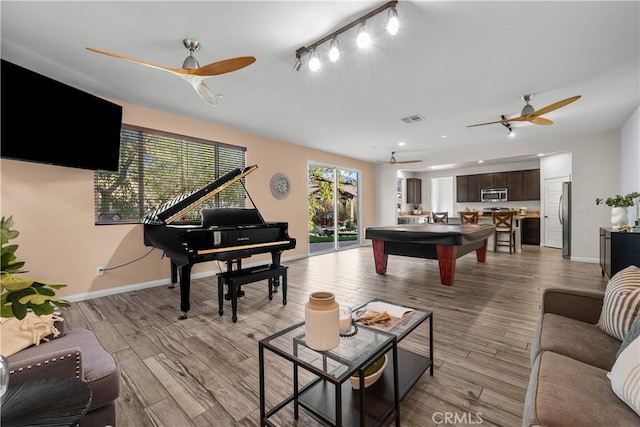 rec room with ceiling fan and light wood-type flooring