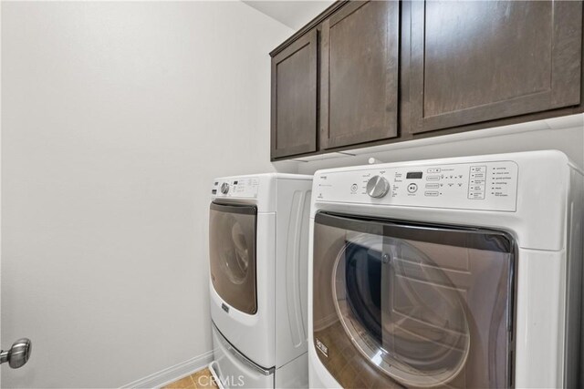 clothes washing area featuring cabinets and washing machine and dryer