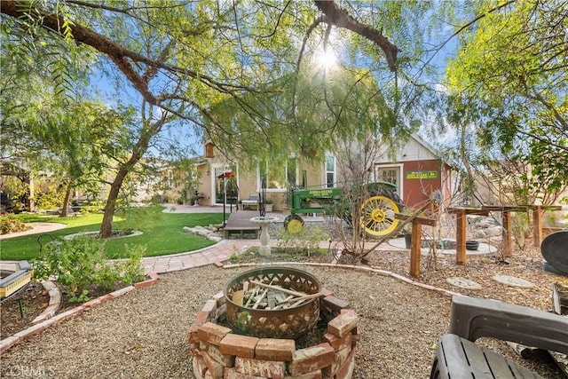 view of property's community featuring a yard and an outdoor fire pit