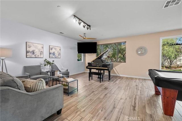 living room featuring billiards, track lighting, light hardwood / wood-style floors, and a healthy amount of sunlight