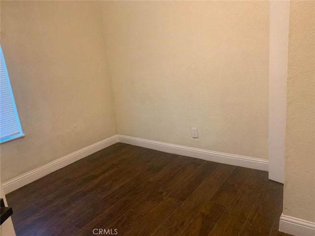 unfurnished room featuring dark wood-type flooring