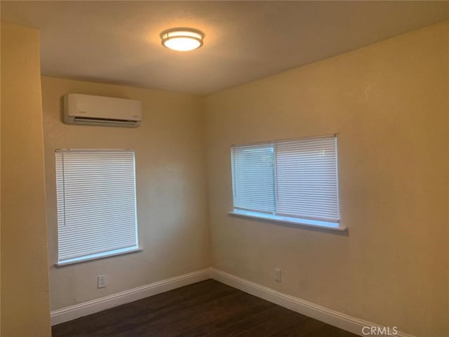 unfurnished room featuring dark hardwood / wood-style floors and a wall mounted AC