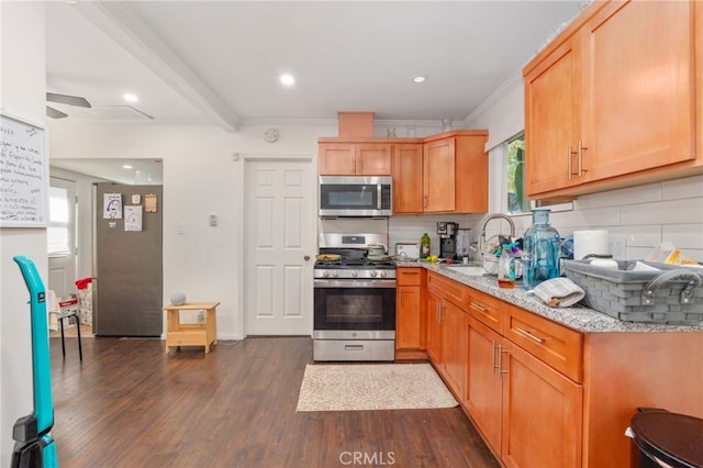 kitchen featuring light stone counters, appliances with stainless steel finishes, dark hardwood / wood-style floors, and decorative backsplash