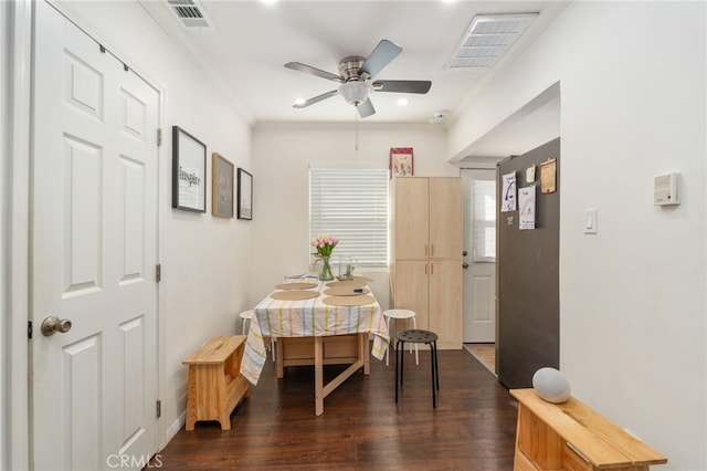 dining area featuring dark hardwood / wood-style flooring, ornamental molding, and ceiling fan