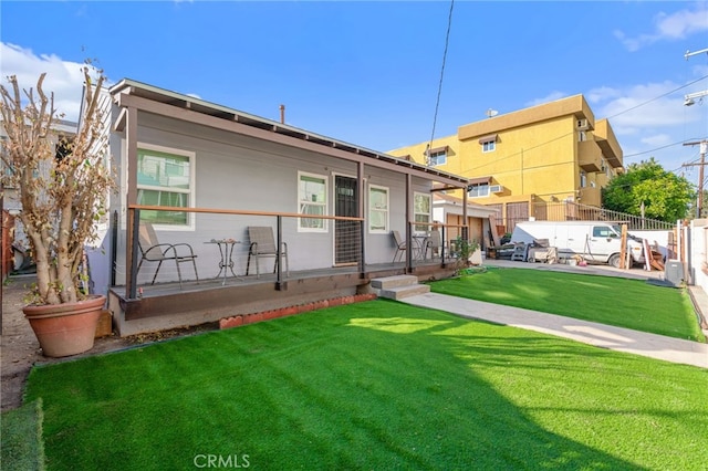 rear view of property featuring a porch and a yard