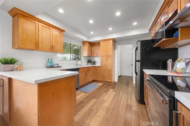 kitchen featuring light countertops, light wood-style flooring, electric range, stainless steel dishwasher, and a peninsula