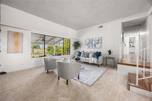 living room featuring visible vents, a textured ceiling, and baseboards