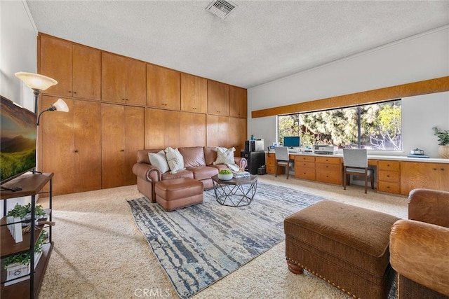 living room featuring built in desk, light colored carpet, and a textured ceiling