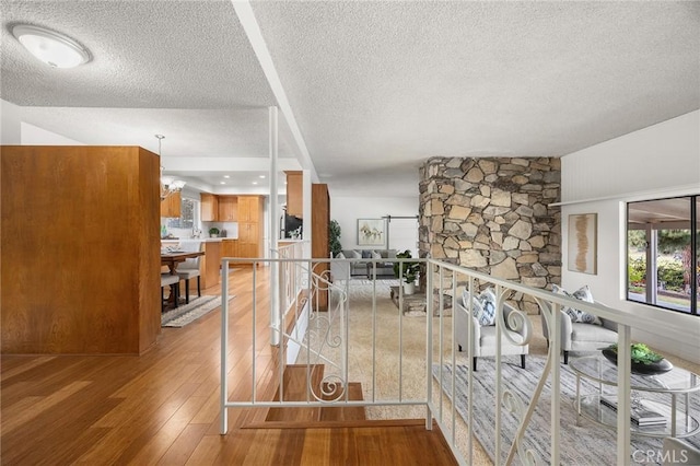 hall featuring a textured ceiling and hardwood / wood-style floors