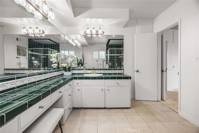 bathroom featuring tile patterned flooring, visible vents, a shower stall, and vanity