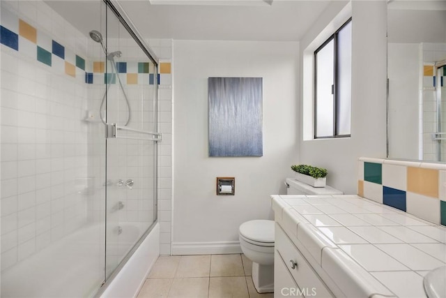 full bathroom featuring enclosed tub / shower combo, toilet, vanity, baseboards, and tile patterned floors