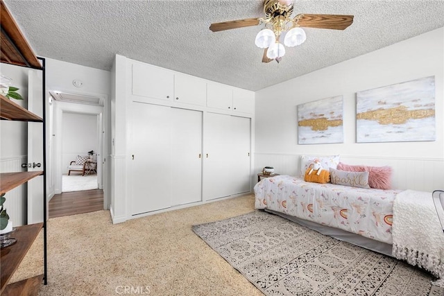 bedroom featuring ceiling fan, a textured ceiling, and a closet