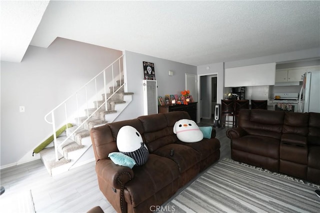 living room featuring light hardwood / wood-style floors and a textured ceiling