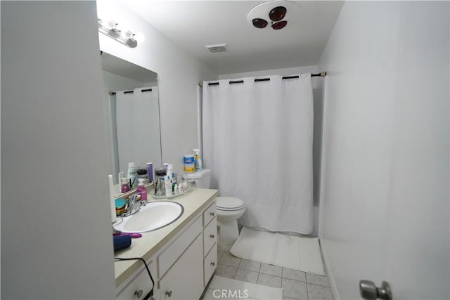 bathroom with tile patterned flooring, vanity, and toilet