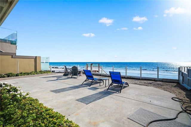 view of patio featuring a water view and a beach view